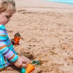 one of the tips for taking baby to the beach for the first time is covering their skin up